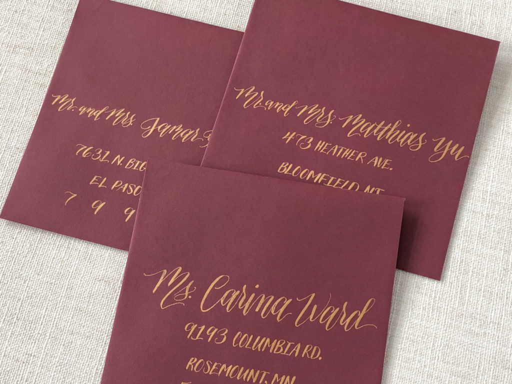 Burgundy envelopes with copper calligraphy addresses